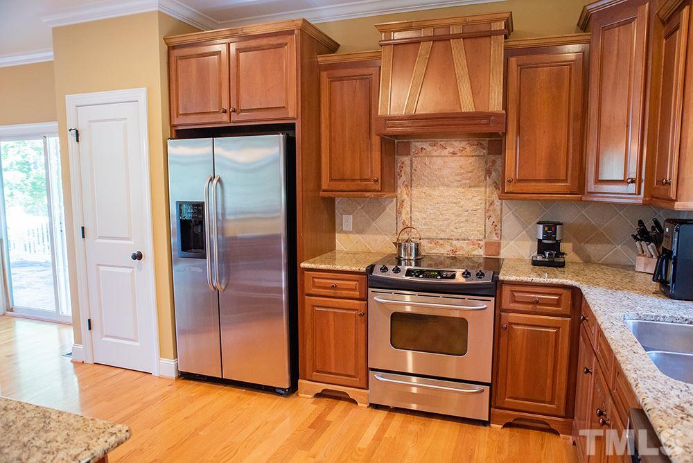 159 Duck Pointe Drive Roxboro, NC 27574 - Photo 11 of 30 a kitchen with granite countertop wooden cabinets stainless steel appliances and a counter space