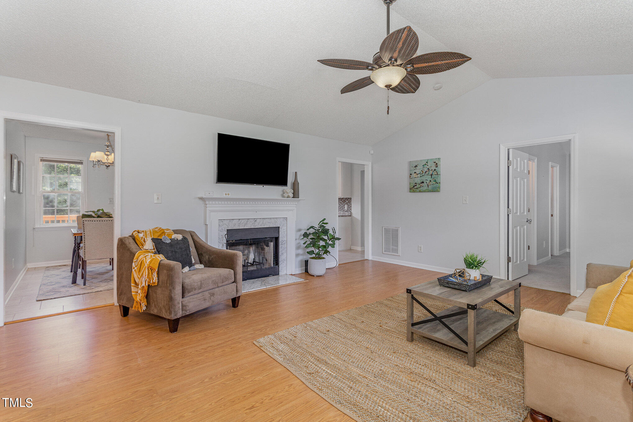 6309 Bridgemont Lane Willow Spring, NC 27592 - Photo 4 of 27 a living room with furniture a fireplace and a flat screen tv
