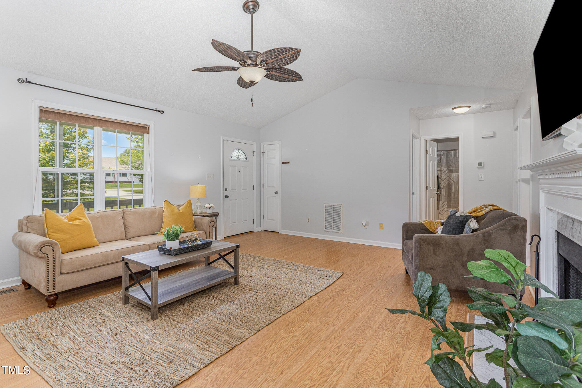6309 Bridgemont Lane Willow Spring, NC 27592 - Photo 5 of 27 a living room with furniture a flat screen tv and a large window