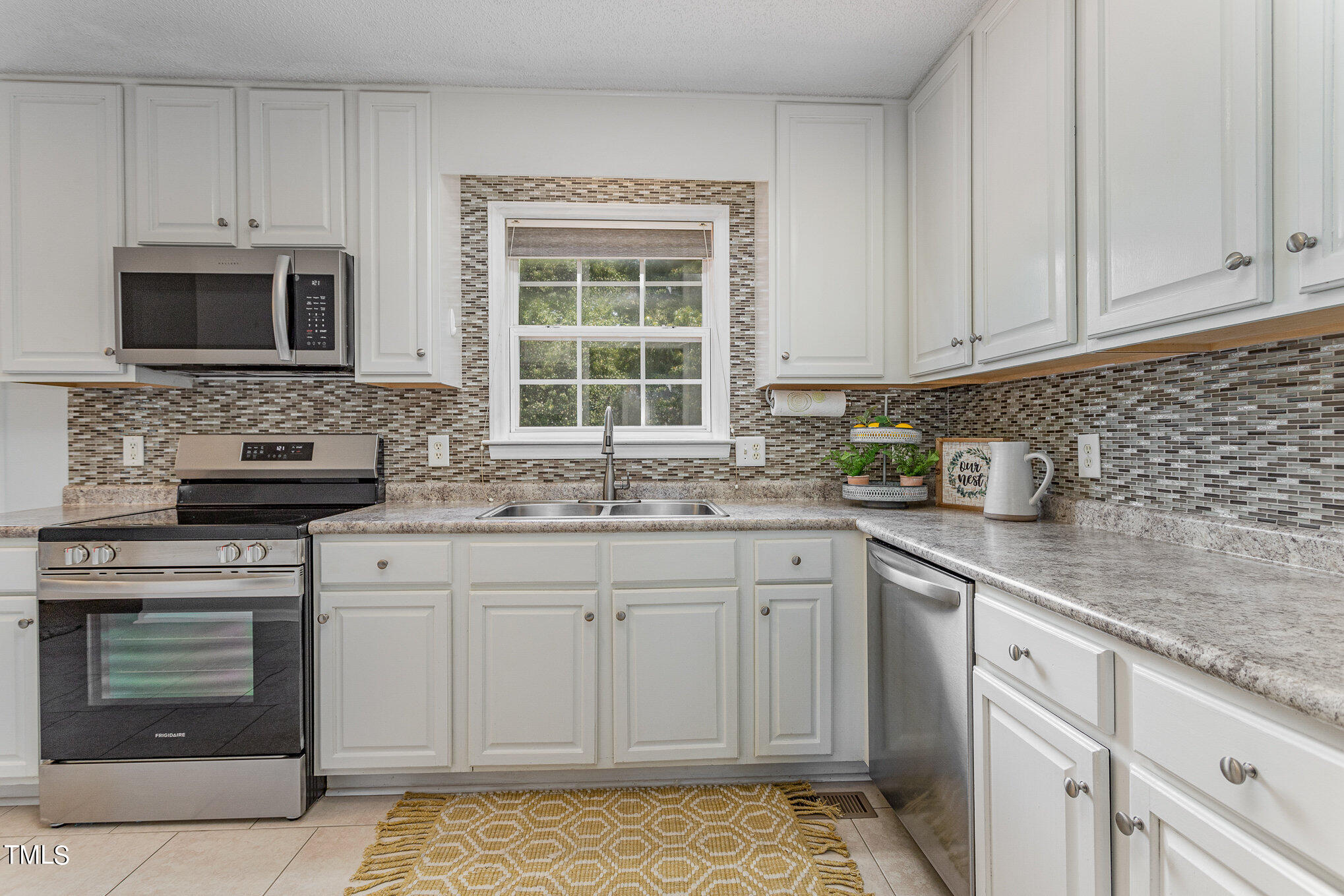 6309 Bridgemont Lane Willow Spring, NC 27592 - Photo 7 of 27 a kitchen with stainless steel appliances granite countertop a sink stove and microwave