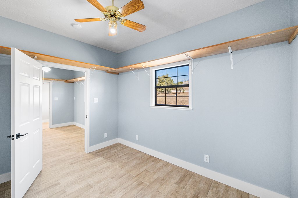 622 Paradise Ranch Road Fredericksburg, TX 78624 - Photo 60 of 90 an empty room with a ceiling fan and a window