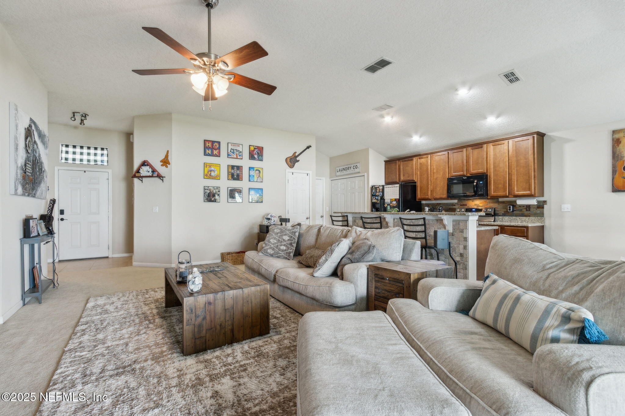 94055 Last Lane Yulee, FL 32097 - Photo 15 of 30 a living room with furniture kitchen view and a chandelier