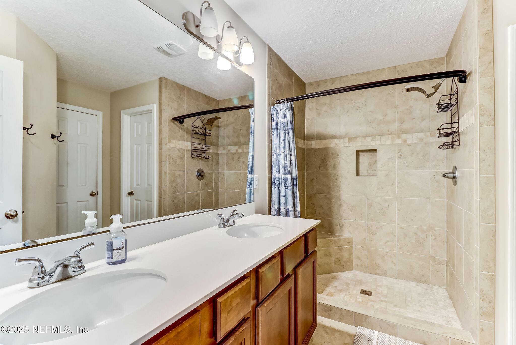 94055 Last Lane Yulee, FL 32097 - Photo 18 of 30 a bathroom with a shower sink vanity and mirror