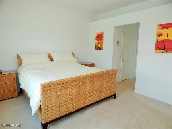 a bed sitting in a bedroom next to a cabinet