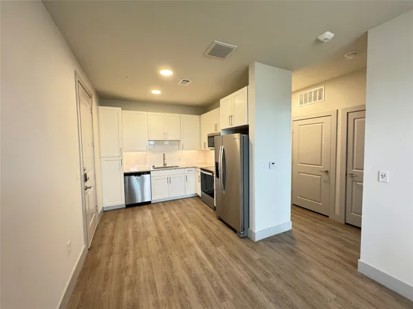 a kitchen with a refrigerator a sink and cabinets