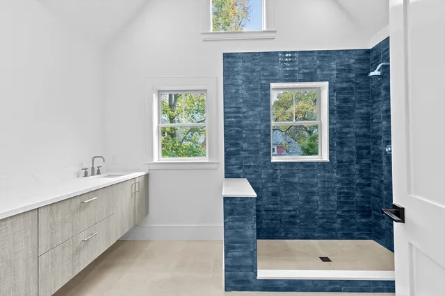 a bathroom with a sink a window and a shower