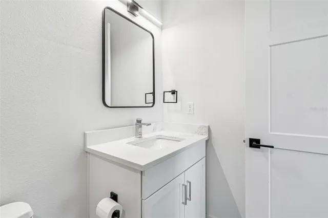 a bathroom with a sink mirror and toilet