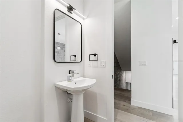a large kitchen with white cabinets and wooden floor