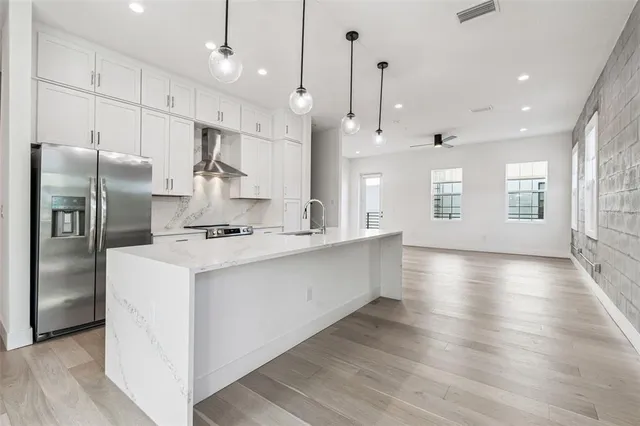 a large kitchen with kitchen island a sink stainless steel appliances and cabinets