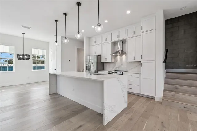 a kitchen with stainless steel appliances granite countertop a sink stove and cabinets