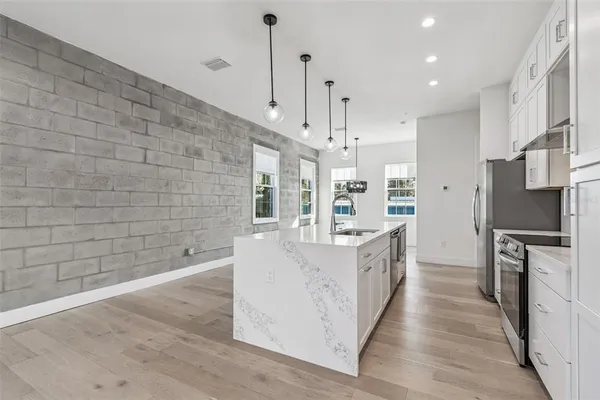 a kitchen with stainless steel appliances a sink stove and refrigerator