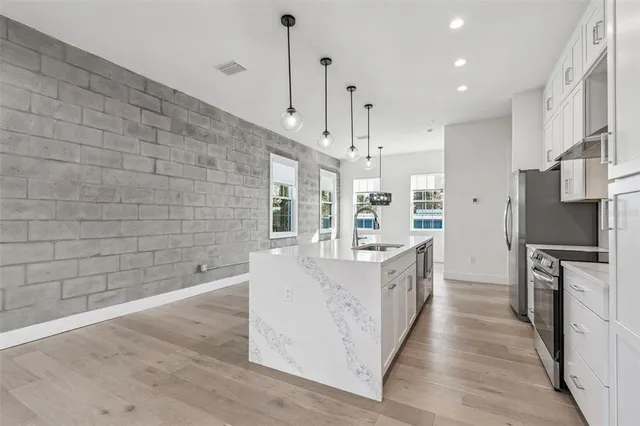 a kitchen with stainless steel appliances a sink stove and refrigerator