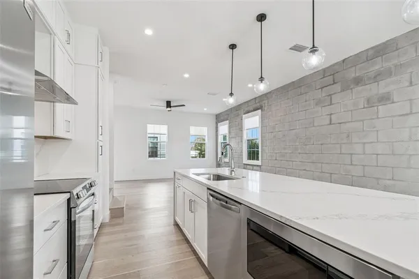 a kitchen with stainless steel appliances granite countertop a sink a stove and a refrigerator