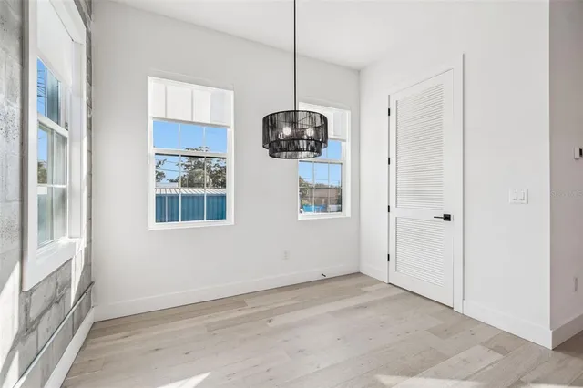 a view of an empty room with a window and wooden floor