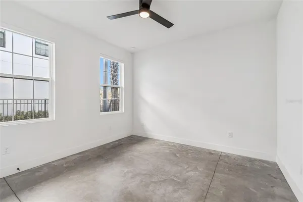 an empty room with closet and windows