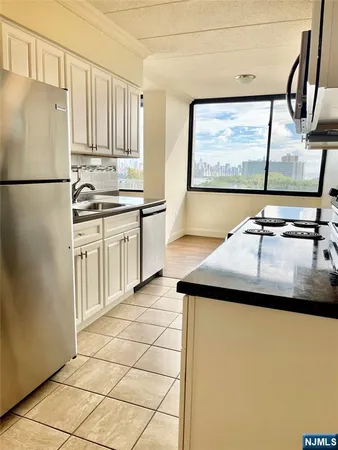 a kitchen with stainless steel appliances a stove a sink and a refrigerator