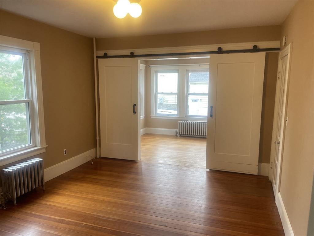44 Sculpin Way, Unit 44 Swampscott, MA 01907 - Photo 7 of 21 a view of an empty room with wooden floor and a window