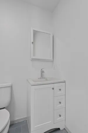 a bathroom with a toilet a sink a vanity and mirror