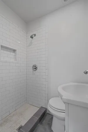 a white toilet sitting next to a bath tub