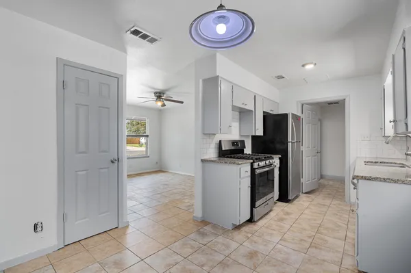a kitchen with stainless steel appliances granite countertop a refrigerator and a stove top oven