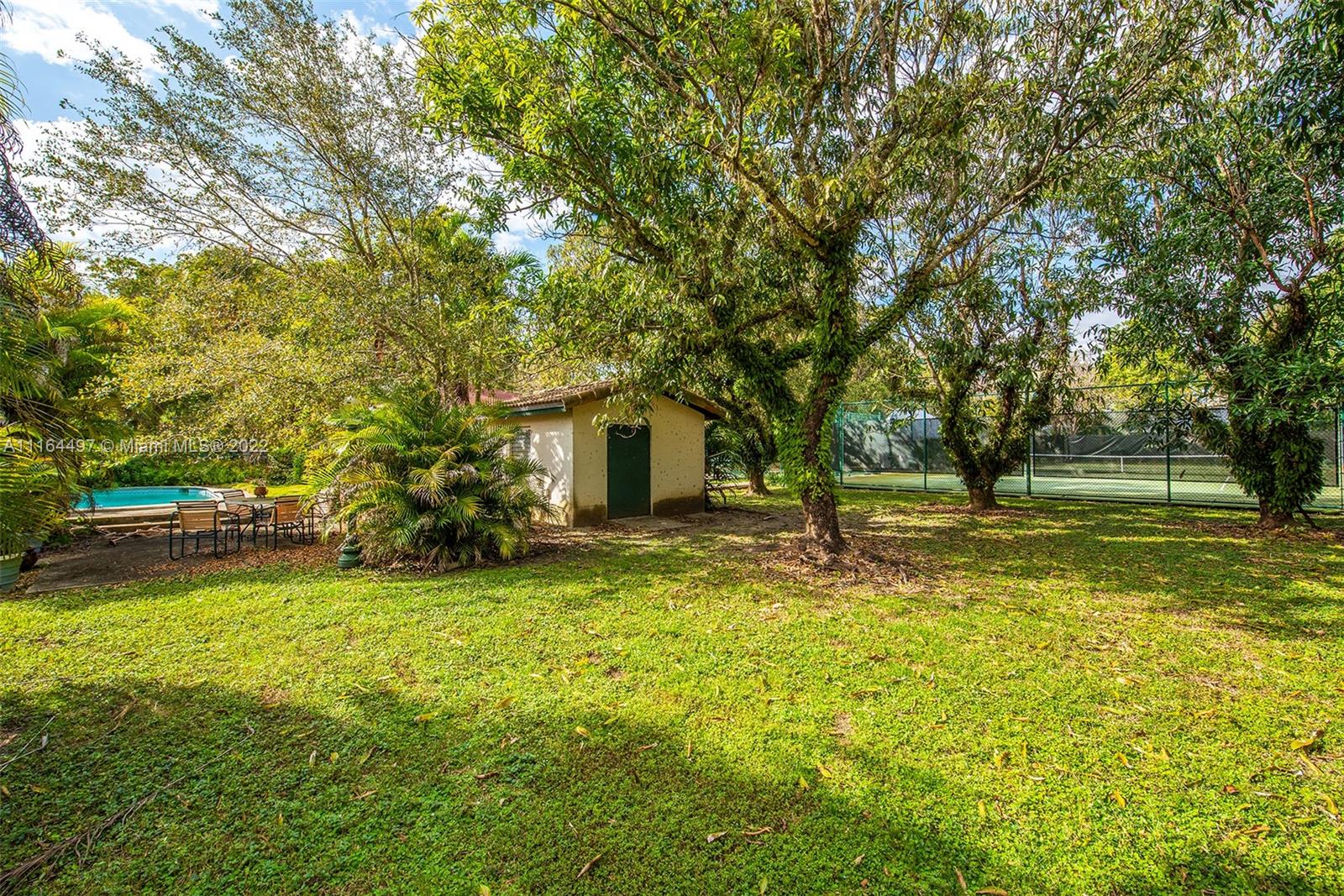7335 Southwest 104th Street Pinecrest, FL 33156 - Photo 11 of 16 a swimming pool with outdoor seating and yard