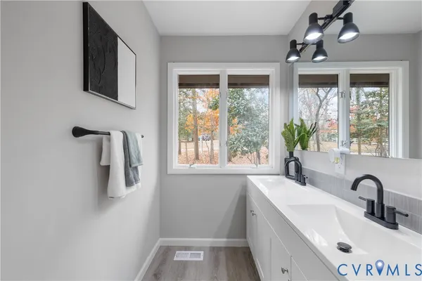 a bathroom with a double vanity sink a mirror and a bathtub