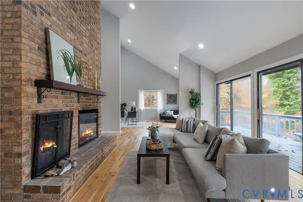a living room with furniture a large window and a fireplace