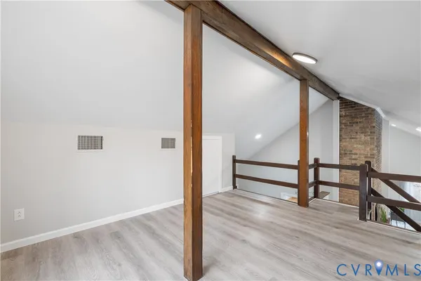 a view of a hallway with wooden floor and staircase