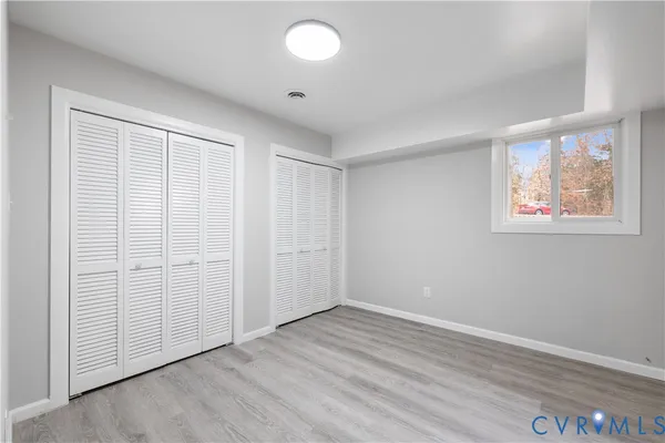 an empty room with wooden floor and white walls