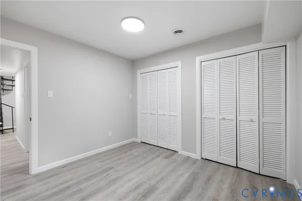 an empty room with wooden floor and closet