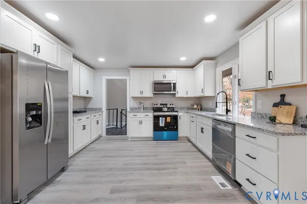 a kitchen with stainless steel appliances granite countertop a refrigerator sink and cabinets