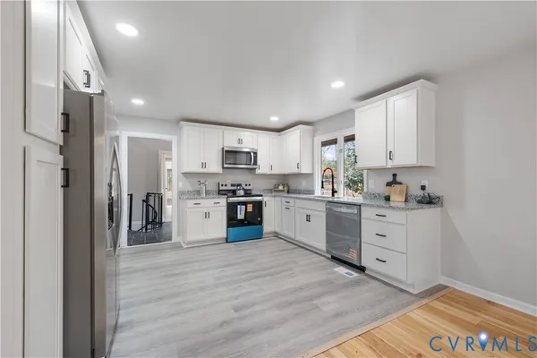 a kitchen with stainless steel appliances granite countertop a refrigerator sink and stove
