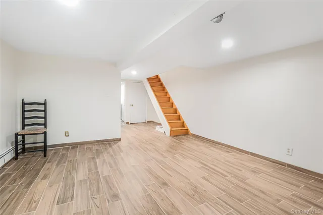 an empty room with wooden floor and white walls