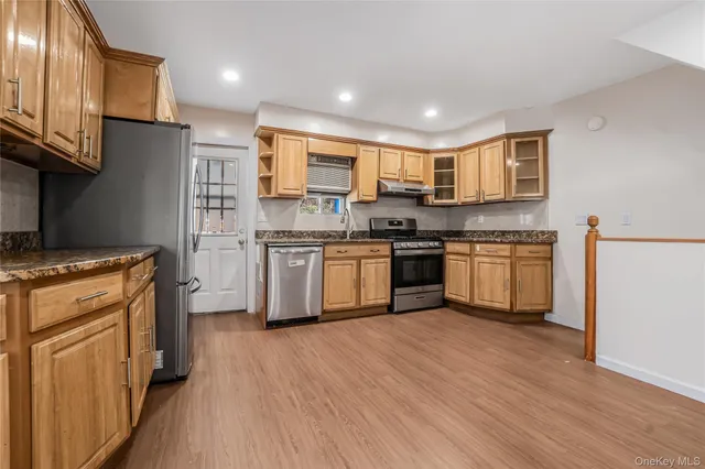 a kitchen with stainless steel appliances granite countertop a stove top oven a sink dishwasher and a refrigerator