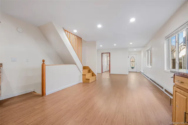 a view of a hall with wooden floor and stairs