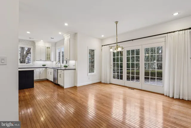 a kitchen with a stove a refrigerator and wooden floor