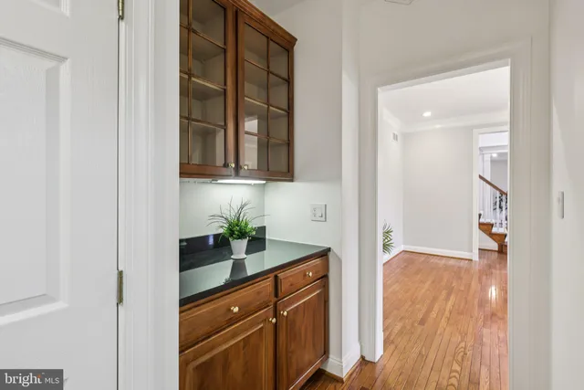 a view of an empty room with wooden floor and a fireplace