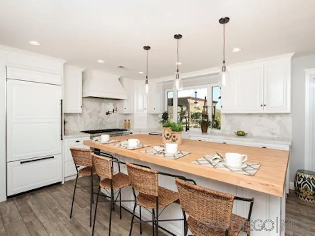 16544 Franzen Farm Road San Diego, CA 92127 - Photo 6 of 25 a kitchen with a table a stove and white cabinets