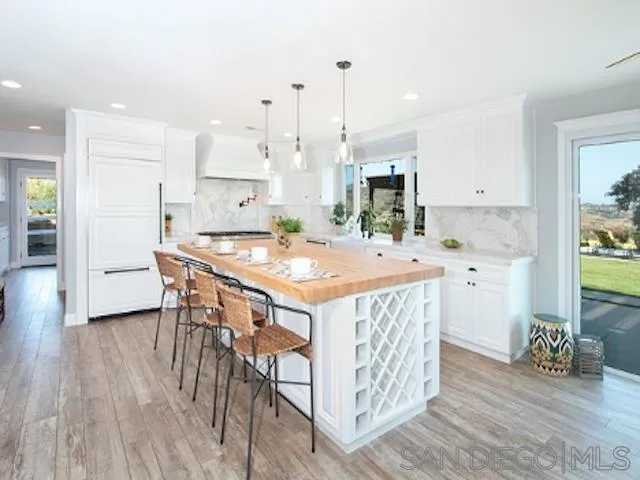 16544 Franzen Farm Road San Diego, CA 92127 - Photo 7 of 25 a kitchen with a sink a stove a dining table and chairs