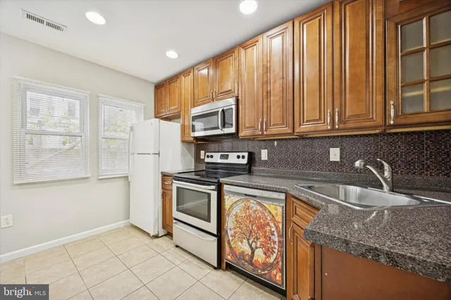 a kitchen with granite countertop a stove a sink and a microwave