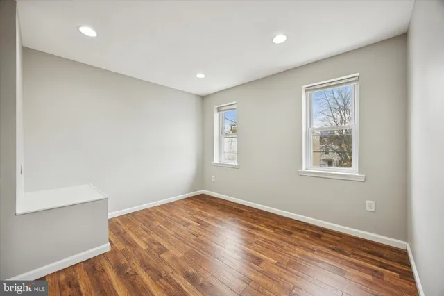a view of empty room with wooden floor