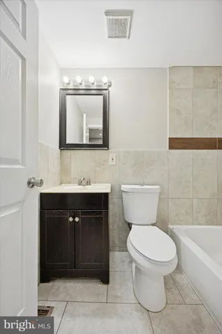 a bathroom with a toilet sink vanity and mirror