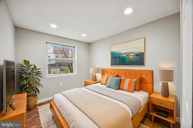 a bedroom with a large bed and a potted plant