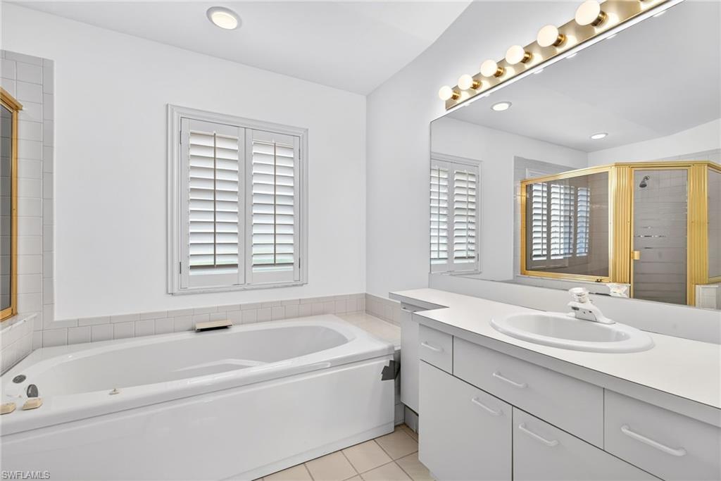 7071 Mill Pond Circle Naples, FL 34109 - Photo 12 of 24 Bathroom with a garden tub, a stall shower, vanity, and light tile patterned floors