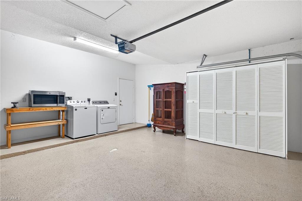 7071 Mill Pond Circle Naples, FL 34109 - Photo 17 of 24 Garage featuring washing machine and clothes dryer and a garage door opener