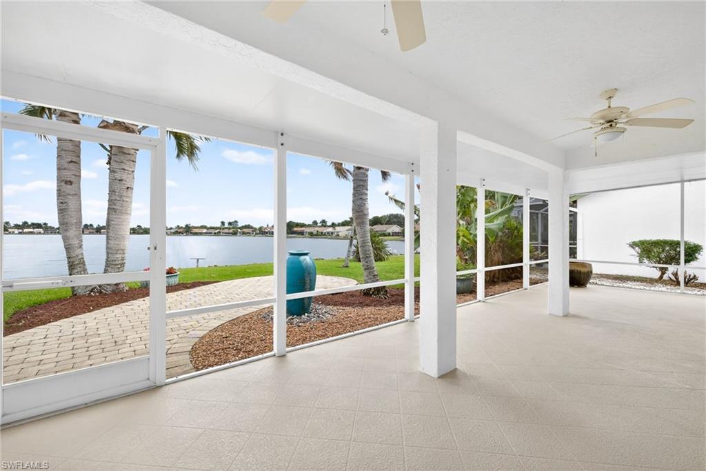 7071 Mill Pond Circle Naples, FL 34109 - Photo 18 of 24 Unfurnished sunroom featuring a ceiling fan, a water view, and a patio area
