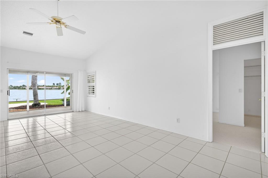 7071 Mill Pond Circle Naples, FL 34109 - Photo 5 of 24 Unfurnished room with a water view, a ceiling fan, light tile patterned floors, and high vaulted ceiling