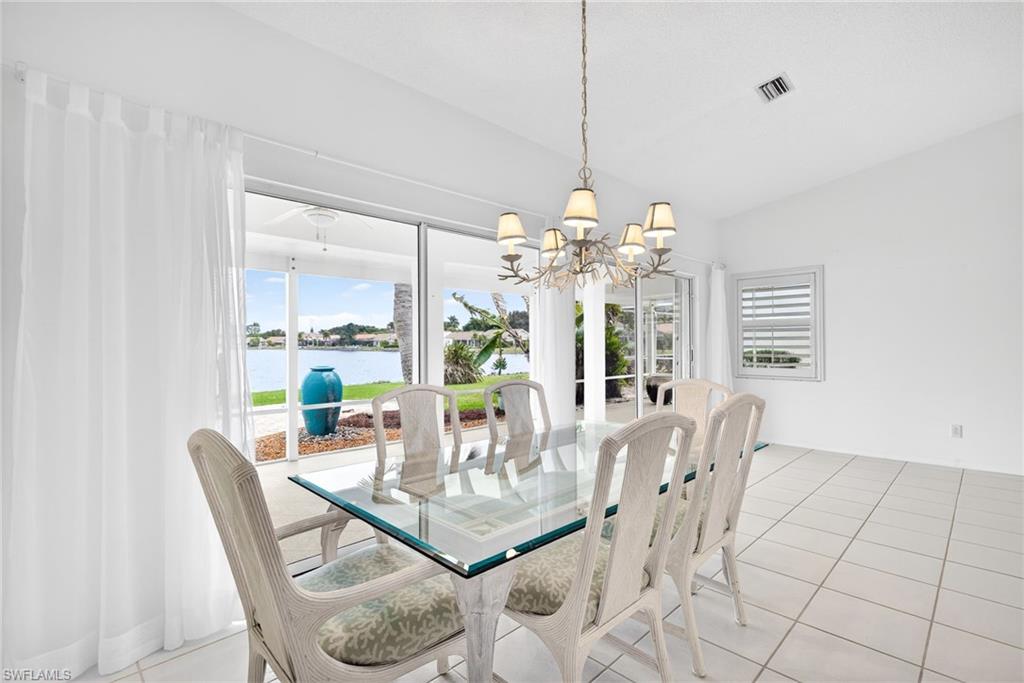 7071 Mill Pond Circle Naples, FL 34109 - Photo 8 of 24 Dining area with light tile patterned floors, plenty of natural light, a water view, and a chandelier
