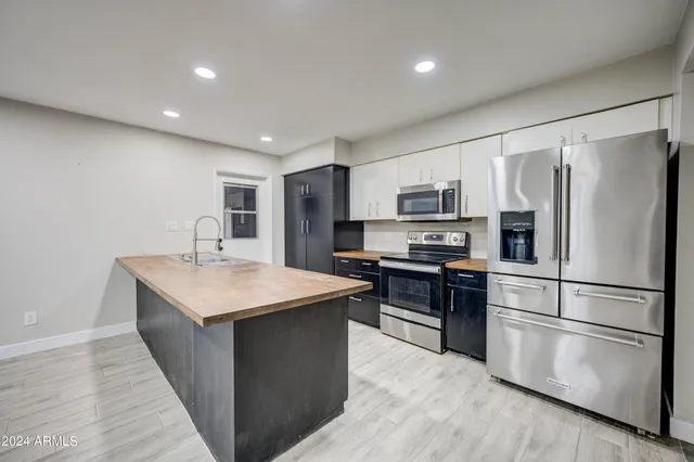 a kitchen with stainless steel appliances granite countertop a refrigerator stove a sink and a microwave