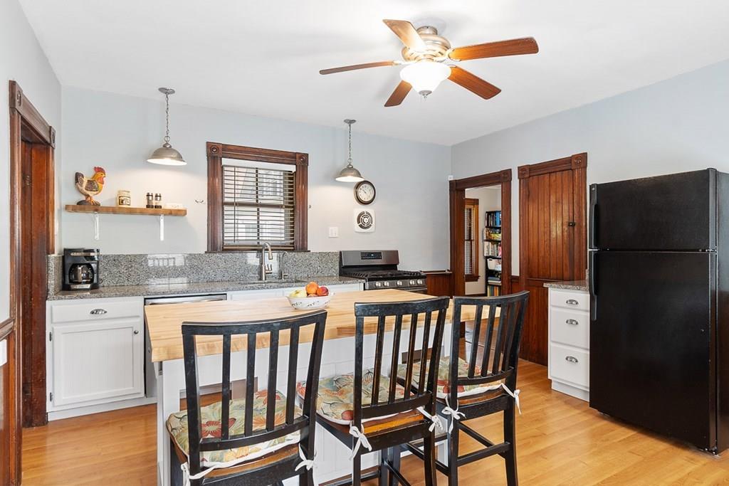 66 Manning Street Hudson, MA 01749 - Photo 5 of 40 a kitchen with stainless steel appliances granite countertop a refrigerator a stove a sink a dining table and chairs with wooden floor